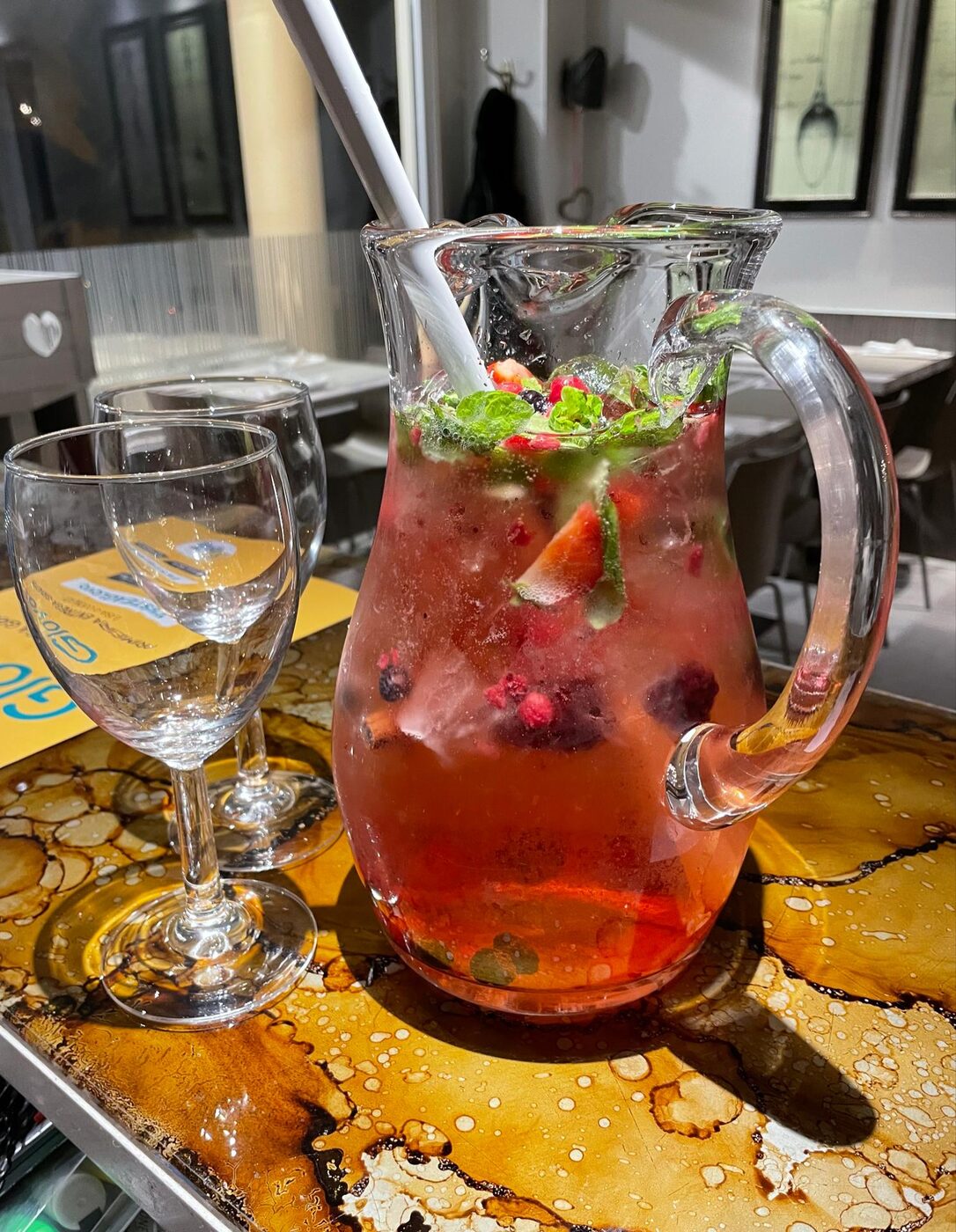 Jarro de sangria com frutos vermelhos e hortelã servido à mesa no Massarella